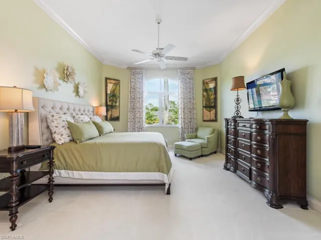 Bedroom featuring baseboards, ceiling fan, ornamental molding, and carpet