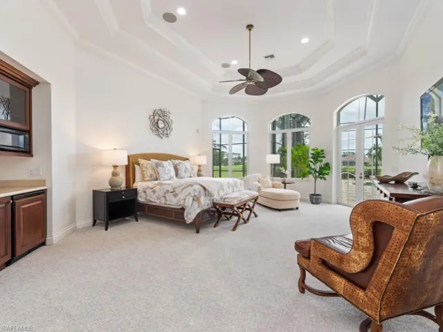 Bedroom with access to exterior, crown molding, french doors, a raised ceiling, and light carpet