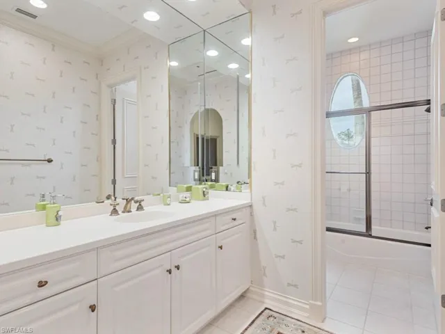 Full bathroom with tile patterned floors, wallpapered walls, visible vents, and vanity