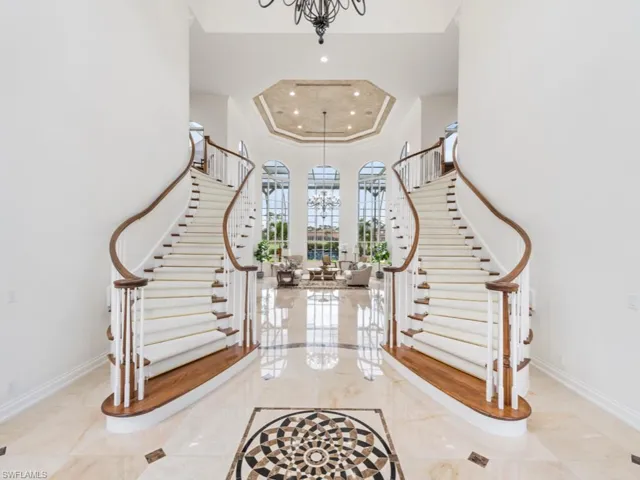 Foyer with baseboards, stairway, and a chandelier