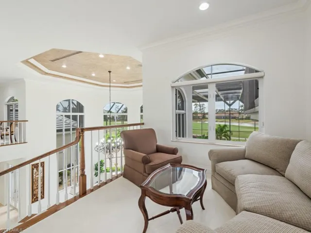 Living room with ornamental molding, a notable chandelier, and recessed lighting