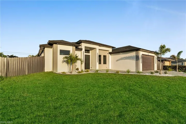 Prairie-style house featuring a front yard, concrete driveway, a garage, and fence