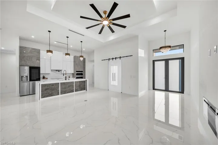 Kitchen with a sink, a raised ceiling, stainless steel fridge with ice dispenser, modern cabinets, and marble finish floor