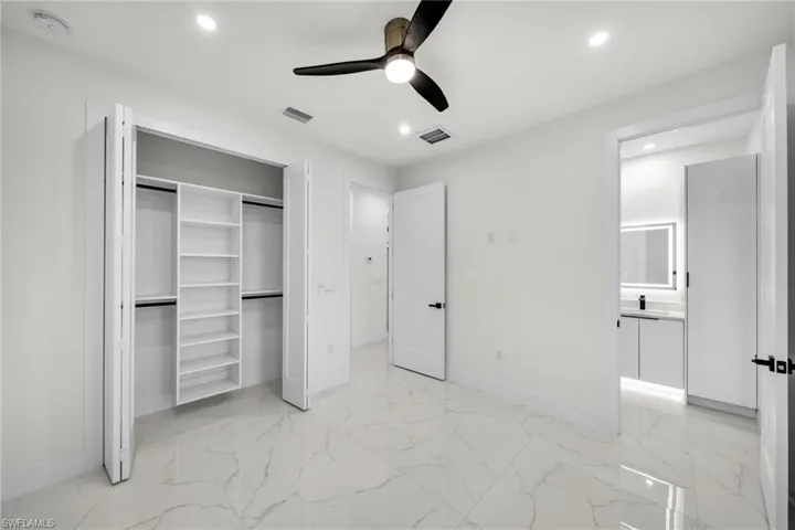 Unfurnished bedroom with marble finish floor, recessed lighting, and visible vents