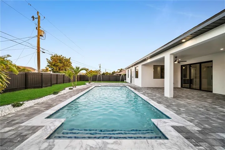 View of swimming pool with a patio, a fenced in pool, a fenced backyard, ceiling fan, and a yard