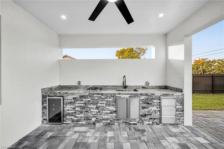 View of patio / terrace featuring a ceiling fan, a sink, area for grilling, and fence