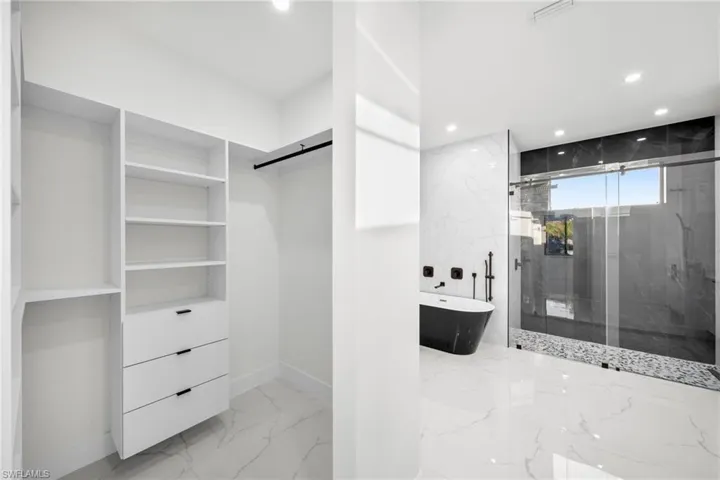 Spacious closet featuring marble finish floor, visible vents, and a barn door