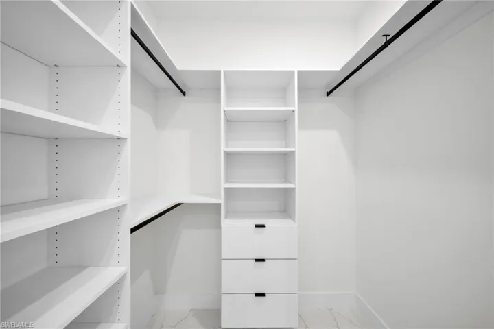 Walk in closet with marble finish floor