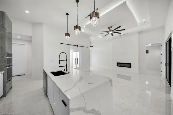 Kitchen featuring modern cabinets, marble finish floor, a sink, and a raised ceiling