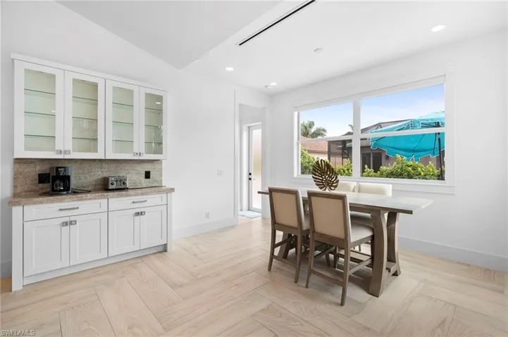 Dining room with vaulted ceiling and light parquet floors