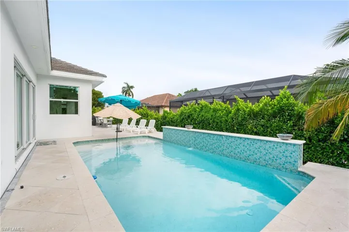 View of swimming pool with a patio, pool water feature, and a lanai