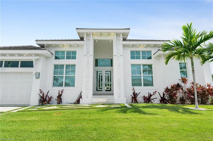 View of front of home with a front yard and a garage