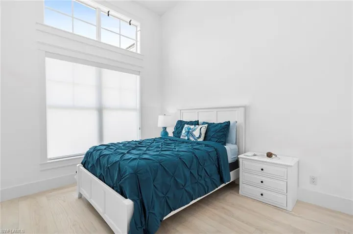 Bedroom with light hardwood / wood-style flooring and multiple windows