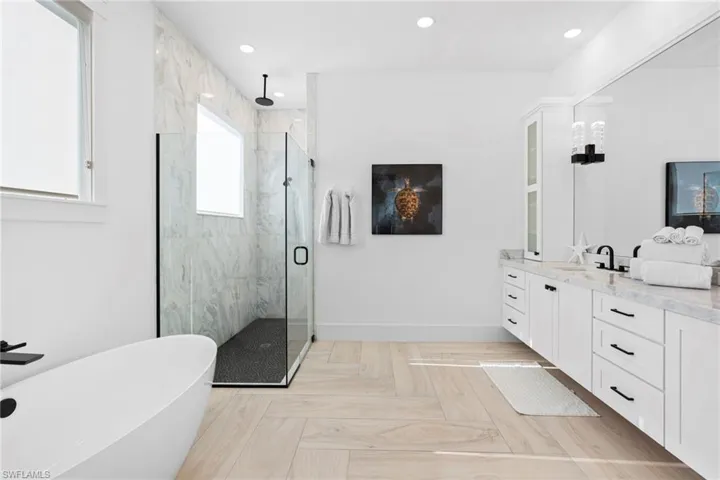 Bathroom with separate shower and tub, parquet floors, and vanity
