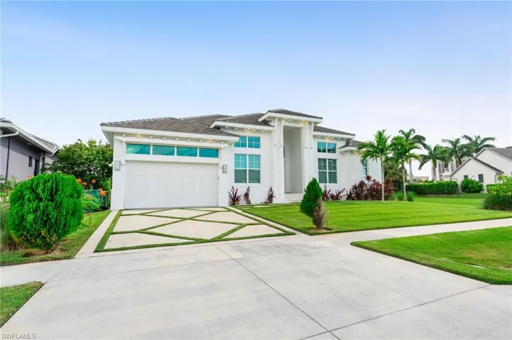 View of front of home featuring a garage and a front lawn