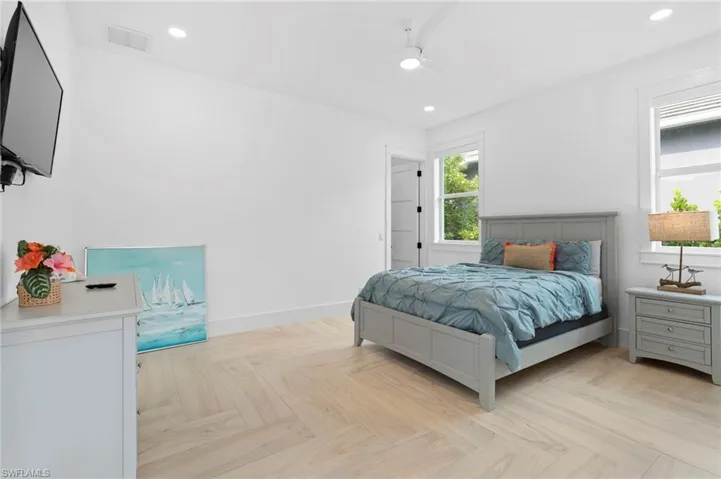 Bedroom with ceiling fan and light parquet floors