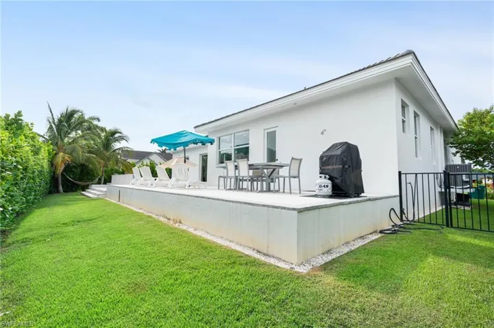 Rear view of house featuring a lawn and a patio area