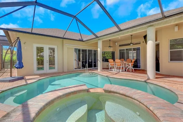 View of pool with a sunroom, a patio, a lanai, a pool with connected hot tub, and a ceiling fan