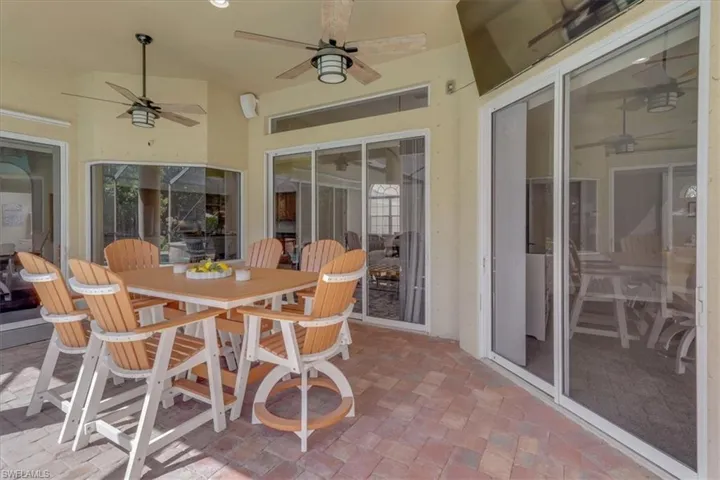 Sunroom with a patio area, outdoor dining area, and a ceiling fan