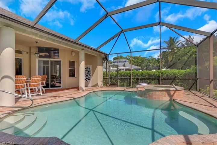 View of pool featuring a sunroom, ceiling fan, a lanai, and a pool with connected hot tub