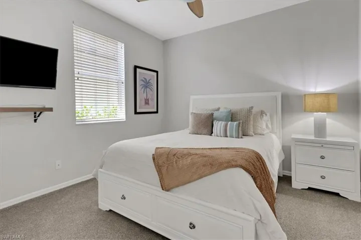 Bedroom featuring light colored carpet and a ceiling fan