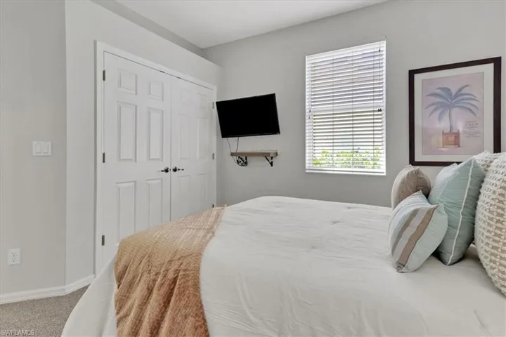 Bedroom featuring carpet floors, multiple windows, and a closet