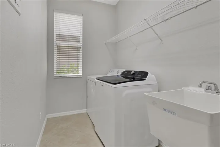 Laundry area featuring separate washer and dryer and light tile patterned floors