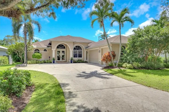 Mediterranean / spanish-style house with french doors, concrete driveway, a garage, stucco siding, and a front yard