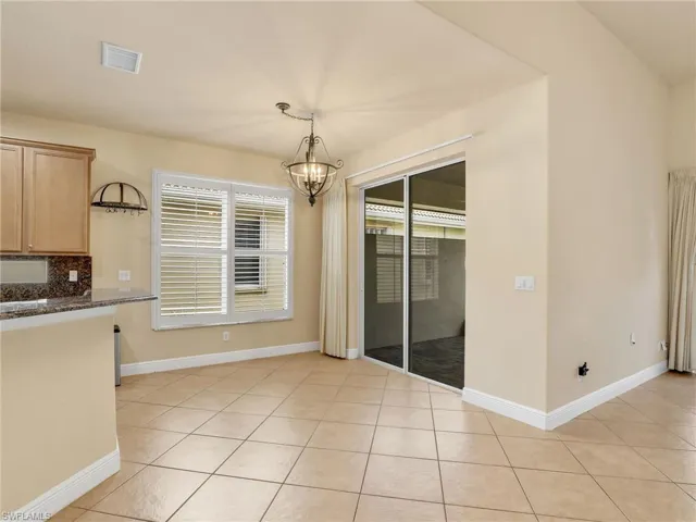 Unfurnished dining area featuring light tile patterned floors and a chandelier