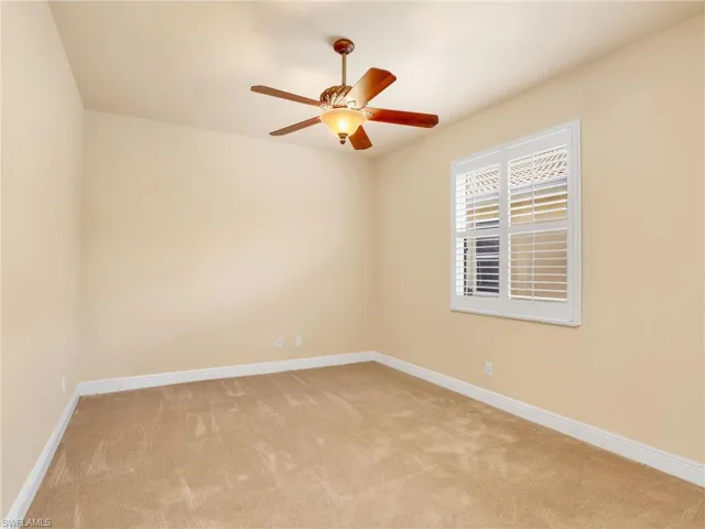 Empty room featuring light colored carpet and ceiling fan