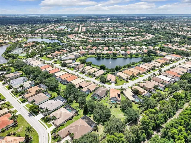 Aerial view of property's location with a nearby body of water and nearby suburban area