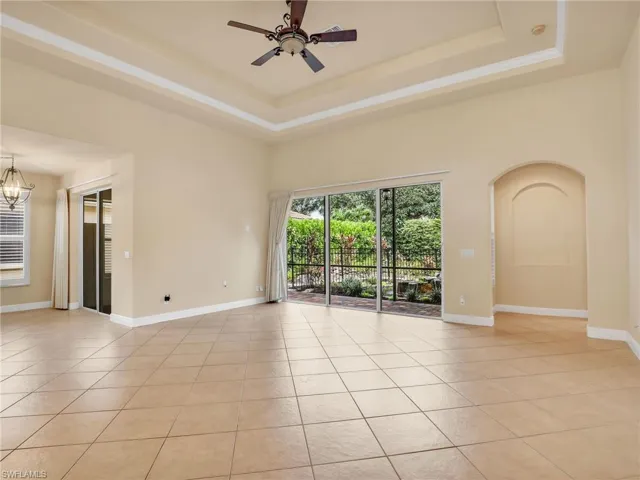 Spare room with a raised ceiling, light tile patterned floors, ceiling fan, and a towering ceiling