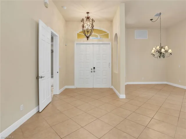 Foyer entrance with a chandelier and light tile patterned floors