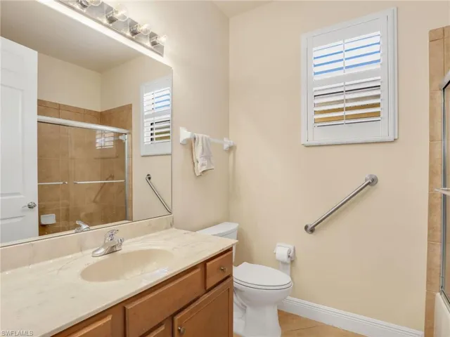 Full bath featuring vanity and light tile patterned flooring