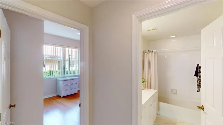Bathroom featuring wood-type flooring and shower / tub combo with curtain