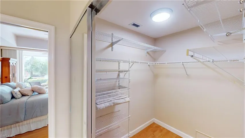 Spacious closet with hardwood / wood-style flooring