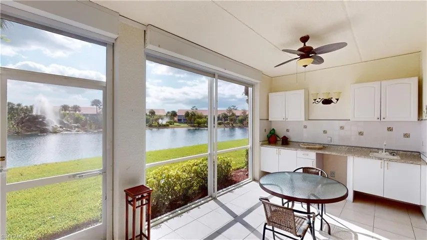 Sunroom / solarium with a water view, sink, and ceiling fan