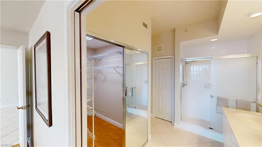 Bathroom featuring tile patterned flooring, vanity, and a shower with shower door