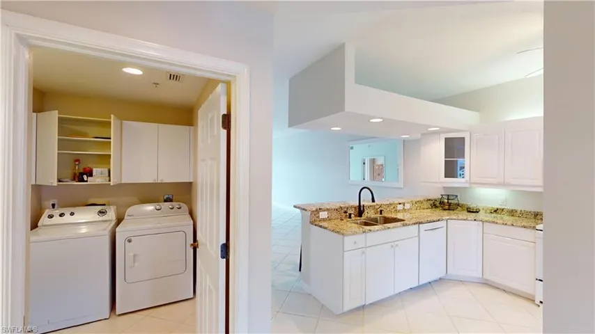 Laundry room featuring cabinets, sink, washer and dryer, and light tile patterned floors