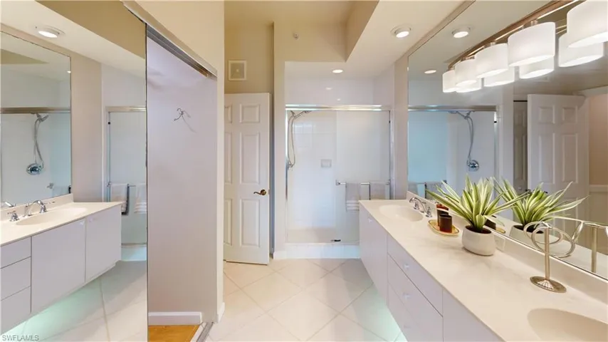 Bathroom featuring vanity, tile patterned flooring, and a shower with shower door