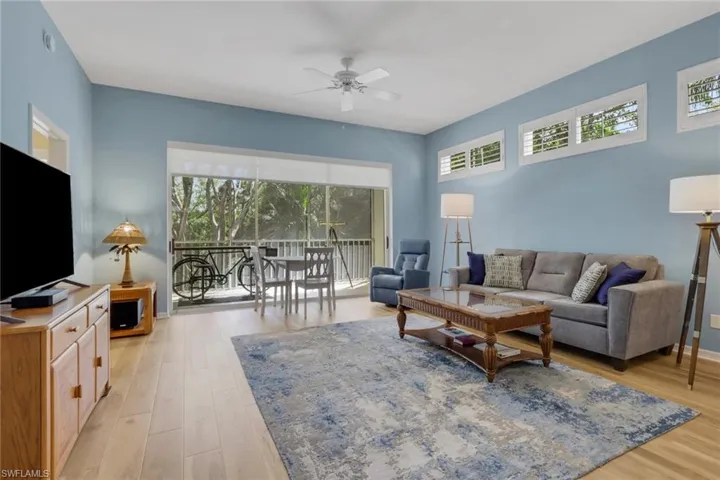 Living area with plenty of natural light, a ceiling fan, and light wood-type flooring