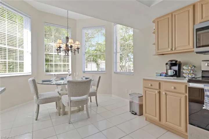 Dining room with a chandelier, light tile patterned floors, and healthy amount of natural light
