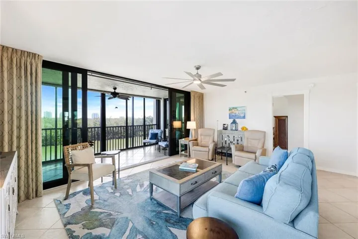 Living area featuring a wall of windows, light tile patterned floors, and ceiling fan