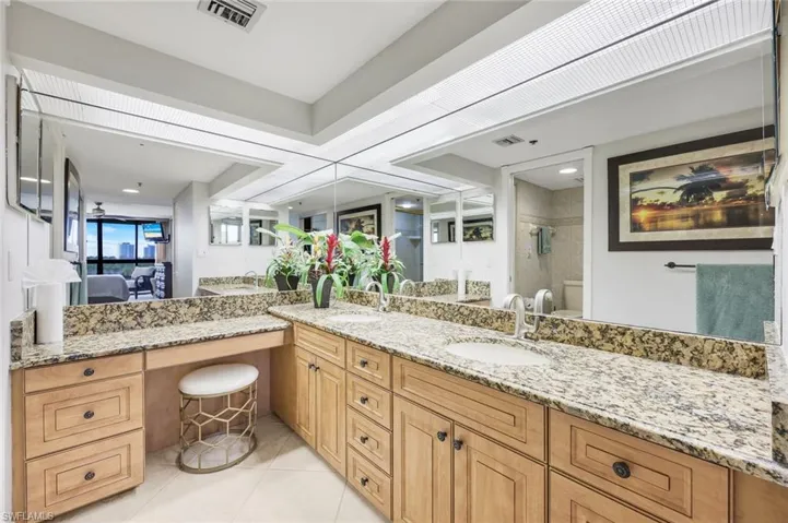 Full bath with double vanity, tiled shower, connected bathroom, and light tile patterned floors