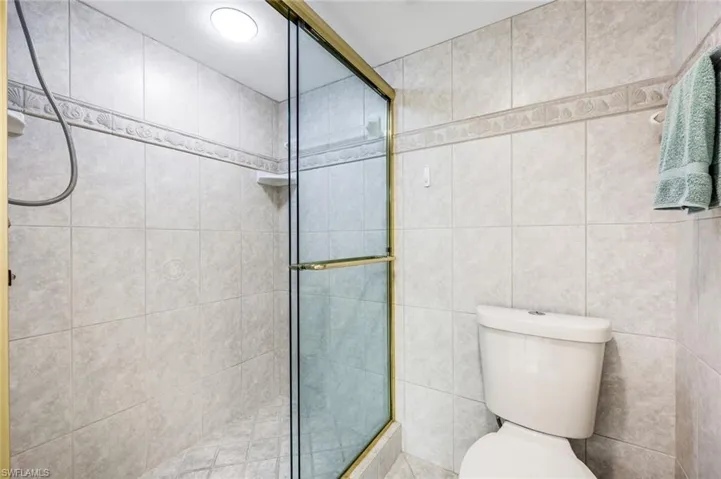 Bathroom with a stall shower and tile walls