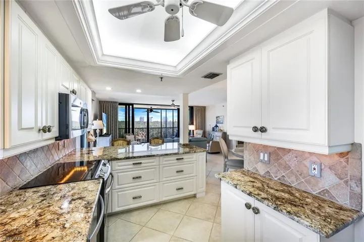 Kitchen updated granite featuring decorative backsplash, a ceiling fan, a peninsula, stainless steel appliances, and recessed lighting