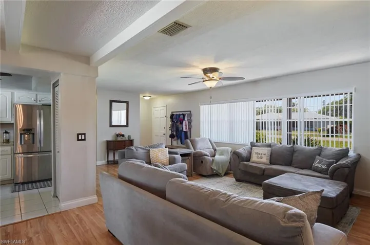 Living room featuring visible vents, plenty of natural light, light wood-style floors, and ceiling fan