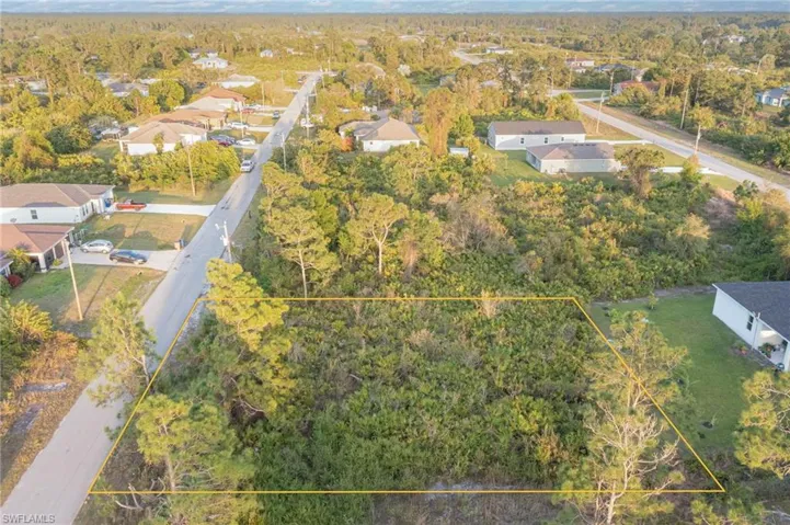 Aerial view featuring a wooded view and a residential view