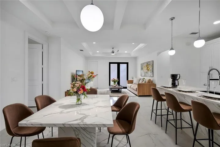 Dining space with sink, a raised ceiling, and ceiling fan