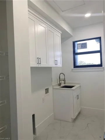 Laundry room featuring washer hookup, cabinets, and sink